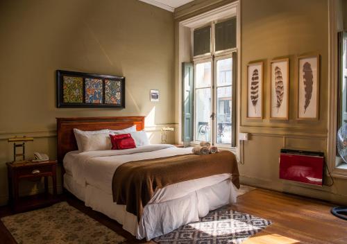 a bedroom with a bed and a large window at Hotel Casa Zañartu in Santiago