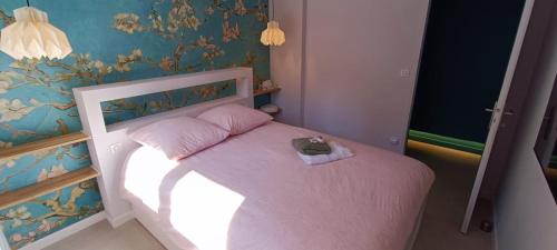 - une petite chambre dotée d'un lit rose avec un animal farci dans l'établissement Superbe T2 avec grande terrasse en centre ville à 5 min à pieds des Arènes de Nîmes, à Nîmes