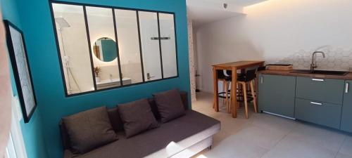 a living room with a couch and a table at Superbe T2 avec grande terrasse en centre ville à 5 min à pieds des Arènes de Nîmes in Nîmes