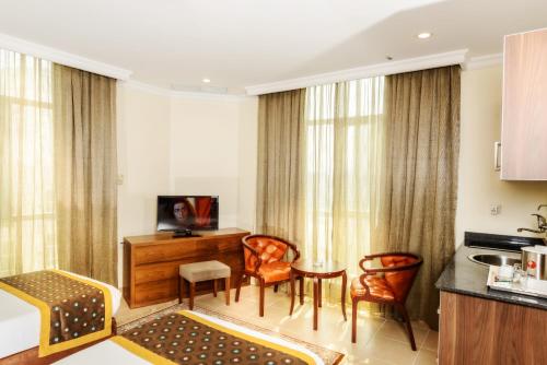 a hotel room with a kitchen and a living room at Bravo Royal Hotel Suites in Kuwait