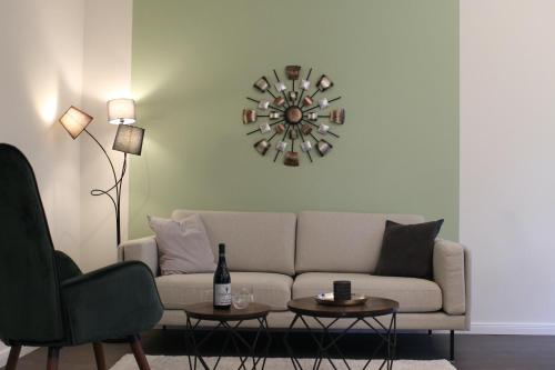 a living room with a couch and a clock on the wall at Appartement Delfi in Flensburg