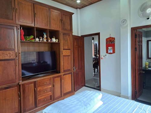 a bedroom with a entertainment center with a flat screen tv at Ciel Homestay in Hue