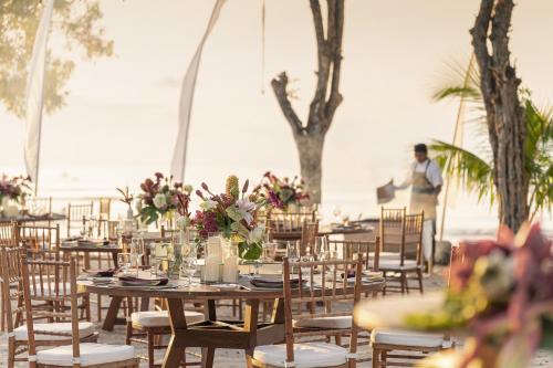 a table set up for a wedding on the beach at Four Seasons Resort Bali at Jimbaran Bay in Jimbaran