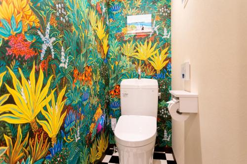 a bathroom with a toilet with a colorful wallpaper at Hotel Sumire ふぐ料理を愉しむ料理宿 in Shimonoseki