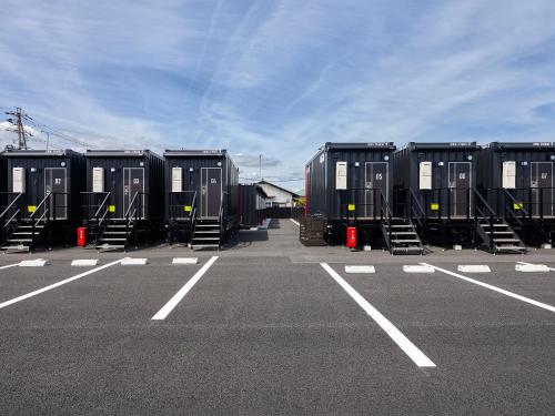 a row of black containers in a parking lot at HOTEL R9 The Yard Minokamo in Minokamo