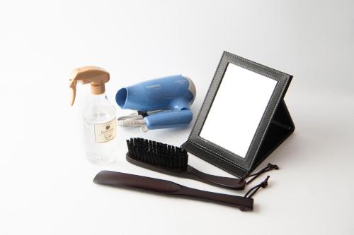 a mirror with a hair dryer a brush and a bottle at HOTEL R9 The Yard Minokamo in Minokamo
