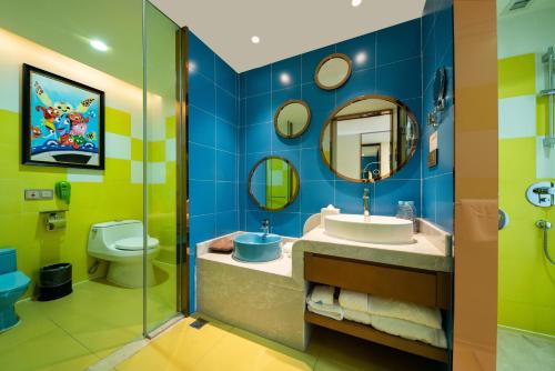 a bathroom with a sink and a toilet and a mirror at Mekong River Jing Land Hotel in Jinghong