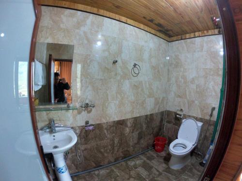 a bathroom with a sink and a toilet and a mirror at Amica House in Sa Pa