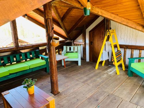 a room with green and blue furniture and a wooden ceiling at Casa "La Moara din Grădină" in Eftimie Murgu