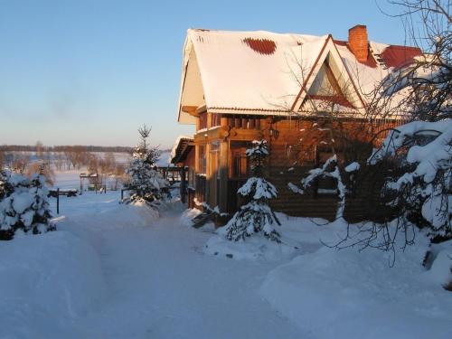a log cabin in the snow with snow covered trees at Andreyevskie Ozera in Andreyevka