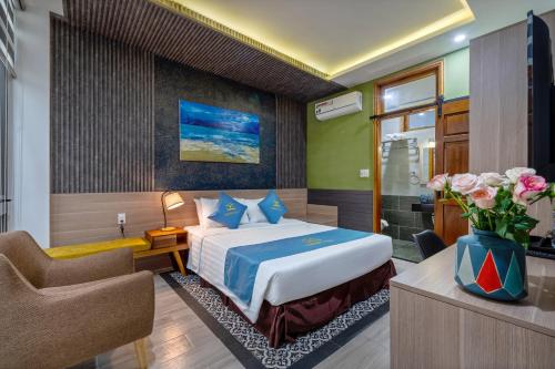 a hotel room with a bed and a chair at Square Villa Hoi An in Hoi An