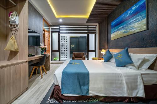 a hotel room with a bed and a desk at Square Villa Hoi An in Hoi An