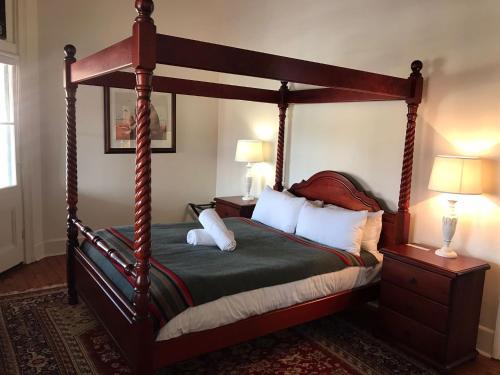 a bedroom with a wooden canopy bed with pillows at Royal Hotel Mandurama in Mandurama