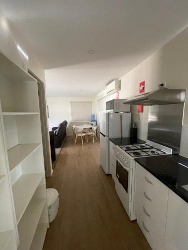 a kitchen with white appliances and a living room at Bundalong Riverside Resort in Bundalong