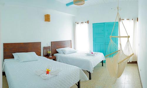 a bedroom with two beds and a hammock at Casa Ramona in Flores