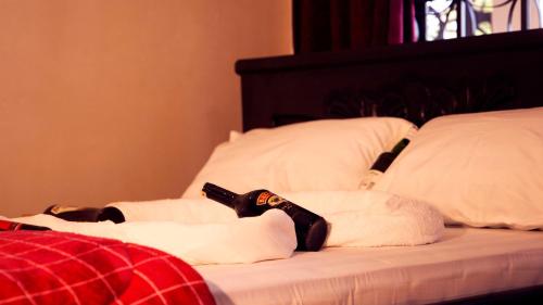 a bed with pillows and a remote control on it at Stusky Lark Mini Hotel Seeta in Seeta