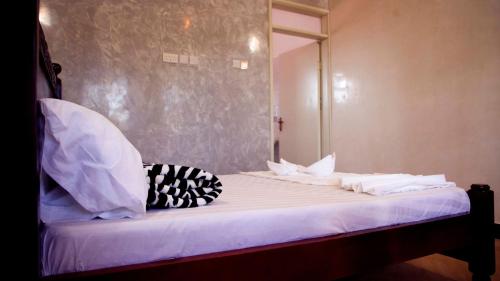 a bed with white sheets and pillows on it at Stusky Lark Mini Hotel Seeta in Seeta