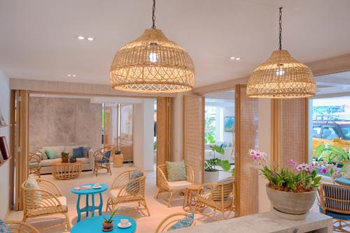 a lobby with chairs and tables and two chandeliers at Vacation Village Phra Nang Inn - SHA Extra Plus in Ao Nang Beach