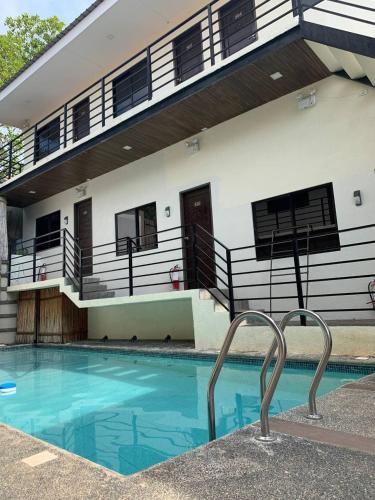 a house with a swimming pool in front of a building at Vela Terraces Hotel in Coron