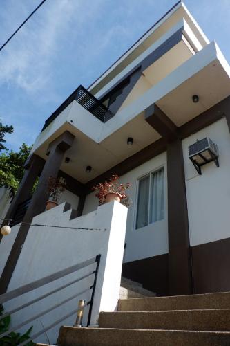 a white house with stairs in front of it at Vela Terraces Hotel in Coron