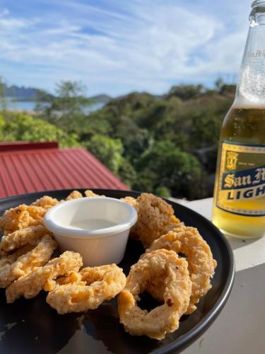 a plate of onion rings and a bottle of beer at Vela Terraces Hotel in Coron