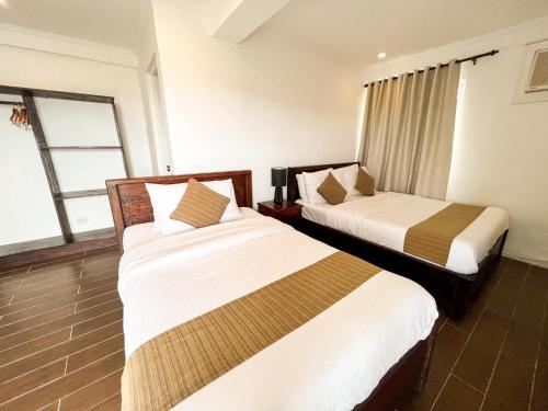 a hotel room with two beds in a room at Vela Terraces Hotel in Coron