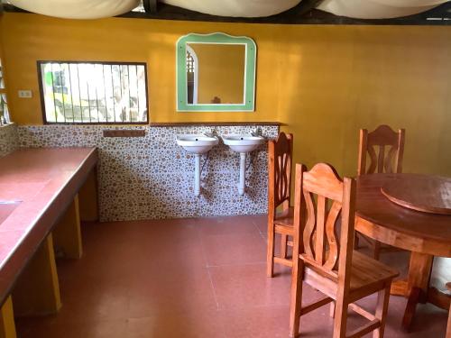 a bathroom with two sinks and a table and chairs at HFA Bldg in Sipalay