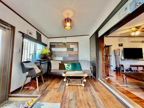 a living room with a couch and a table at Kominka Okinawa in Okinawa City