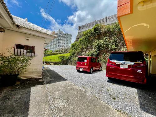 a red van is parked next to a house at Kominka Okinawa in Okinawa City