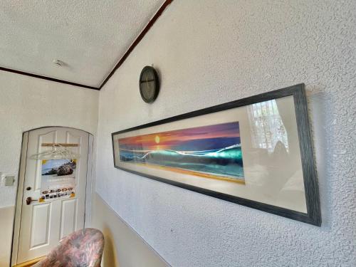 a picture hanging on a wall with a clock at Kominka Okinawa in Okinawa City