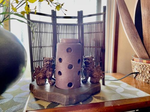 a candle on a table with some figurines on it at Kominka Okinawa in Okinawa City