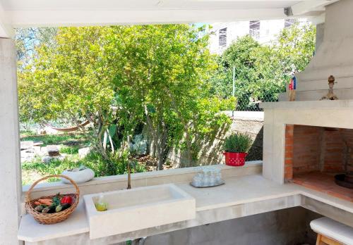 cocina con fregadero y chimenea en Malo more Holiday home, en Mali Ston