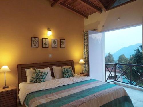 1 dormitorio con cama y ventana grande en Whistling Thrush Cottage, Bhimtal (2bhk) en Nainital