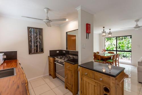 a kitchen with a stove top oven next to a table at Honeybee House in Kuranda