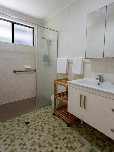 a bathroom with a sink and a shower at Honeybee House in Kuranda