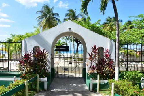 a gate in a garden with palm trees and plants at Czar's Sanctuary- Apt B4 at Sandcastle in Ocho Rios