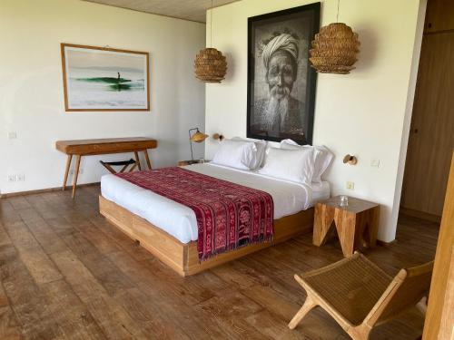 a bedroom with a large bed and a table at Balian Prana in Selemadeg