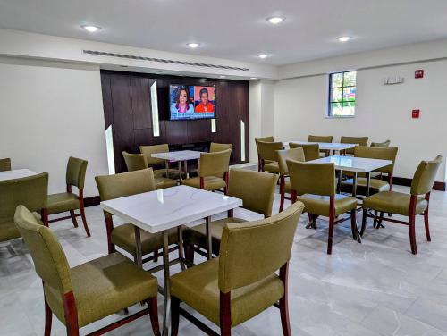 a dining room with tables and chairs and a tv at La Quinta Inn by Wyndham Temple in Temple