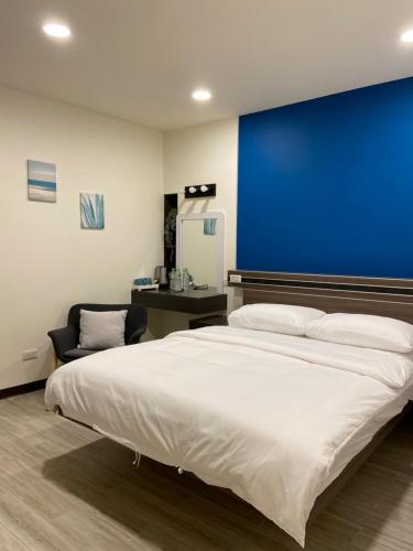 a bedroom with a large bed and a blue wall at 小島上island in Dongyin