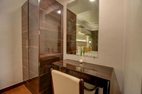 a bathroom with a wooden vanity and a mirror at Elite Hotel in Lonavala