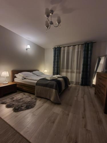 sypialnia z łóżkiem, komodą i oknem w obiekcie Apartament w lesie w mieście Lipnica