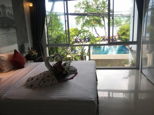 a room with a bed with a swan decoration on it at The Front Hotel and Apartments in Patong Beach