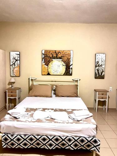a bedroom with a large bed with two tables at Nautica Hotel Apartments in Stavromenos