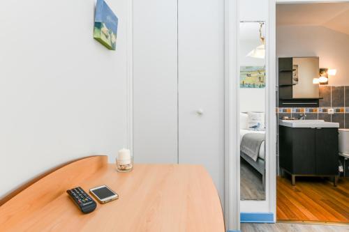 a room with a wooden table with a remote control at Logis Hotel de France in Mimizan-Plage