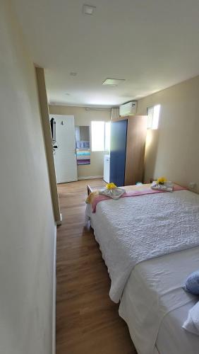 a bedroom with two beds and a kitchen with a refrigerator at Flat Vista Mar Noronha in Fernando de Noronha