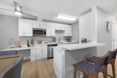 a kitchen with white cabinets and a table and chairs at Cute Delightfully Remodeled Spacious Condo condo in Kent