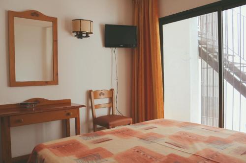 a bedroom with a bed and a desk and a window at Hotel Parc in Roses