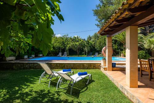 a yard with two chairs and a swimming pool at Can Big Charles in Pollença