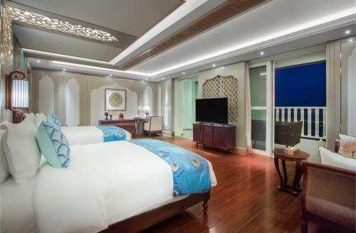 a bedroom with a large bed and a television at Mekong River Jing Land Hotel in Jinghong