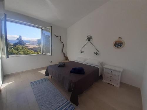 a bedroom with a bed and a large window at bed and breakfast Murales Orgosolo in Orgosolo